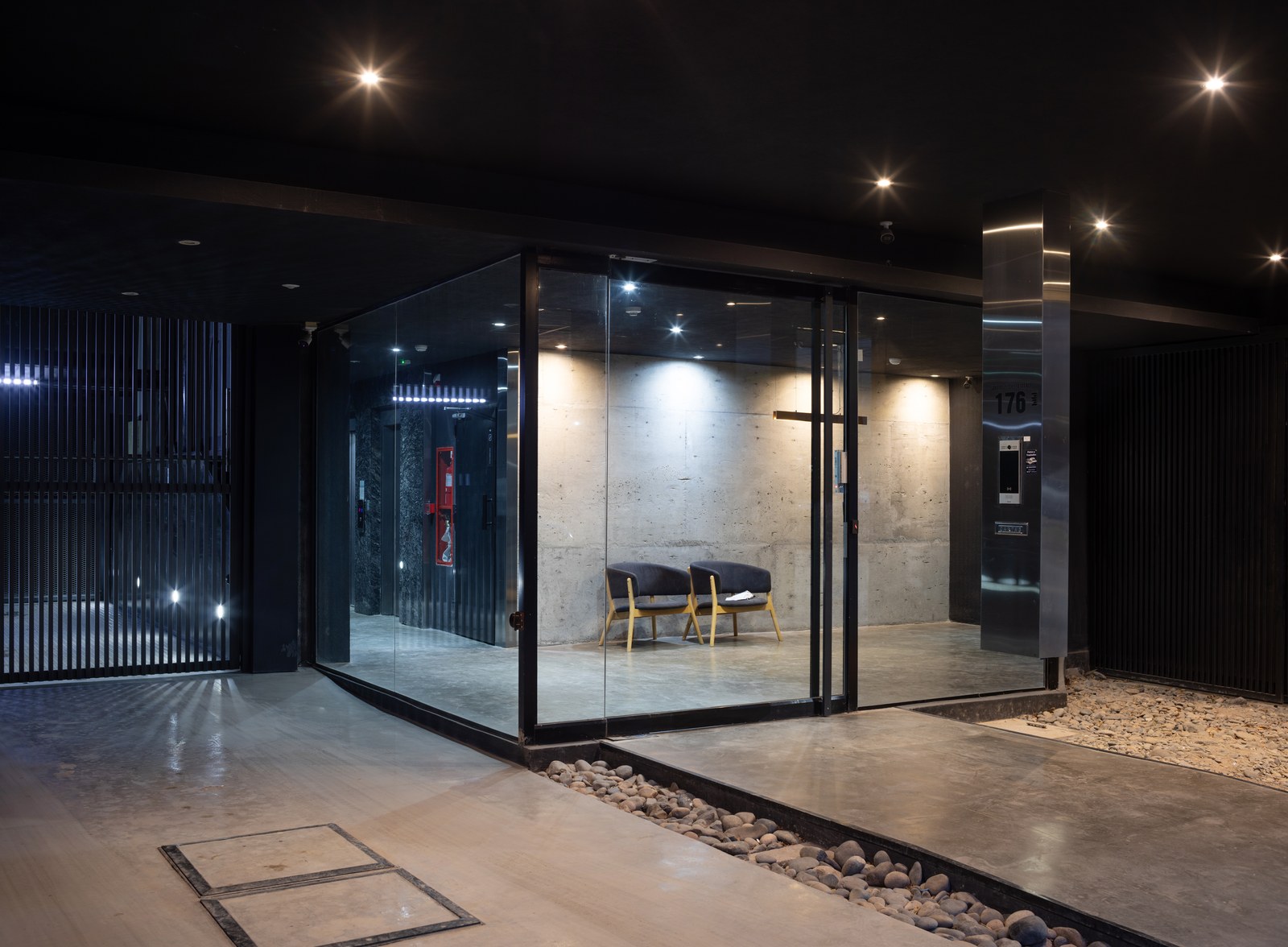 Dommo: Acceso vidriado de noche, con el hall iluminado
